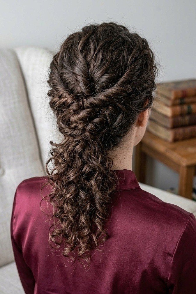Twisted faux updo with the back pinned and curls cascading below, dark brown hair from above and behind