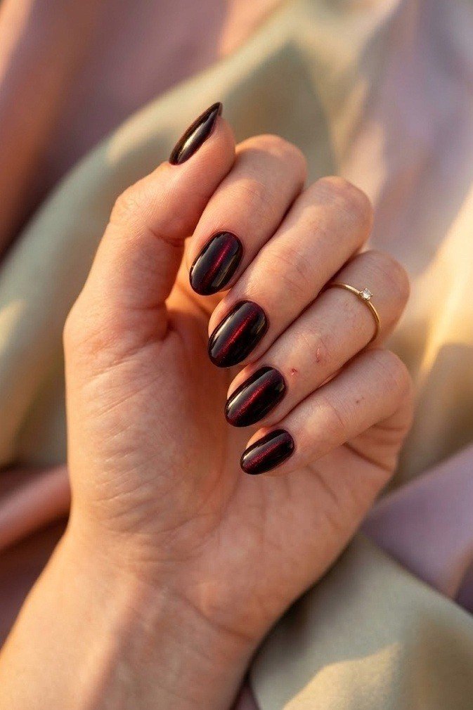 Black cherry velvet nails on short soft almond nails with a thin red center lift