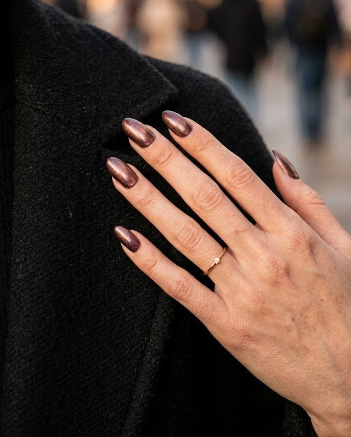 Bronze-plum metallic chrome-effect polish on almond nails