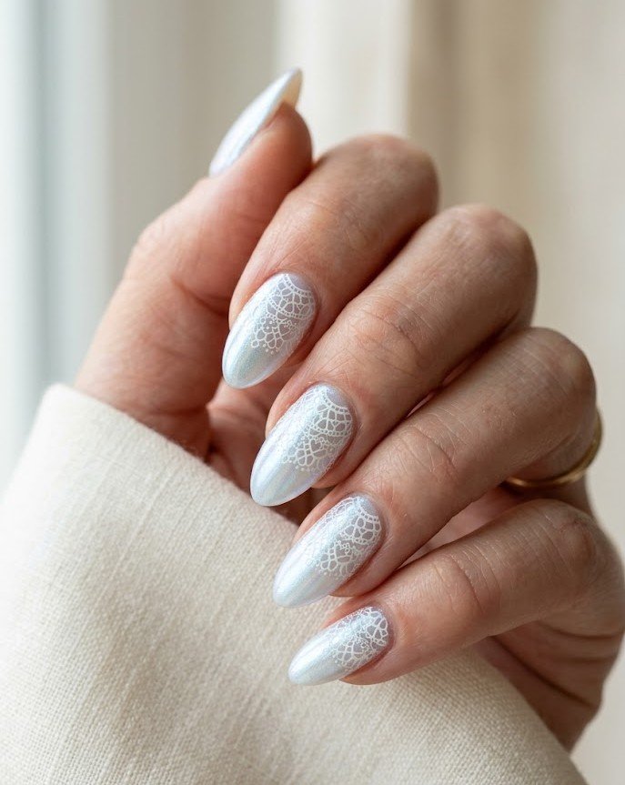Doily pattern over soft chrome nails with a glowing finish