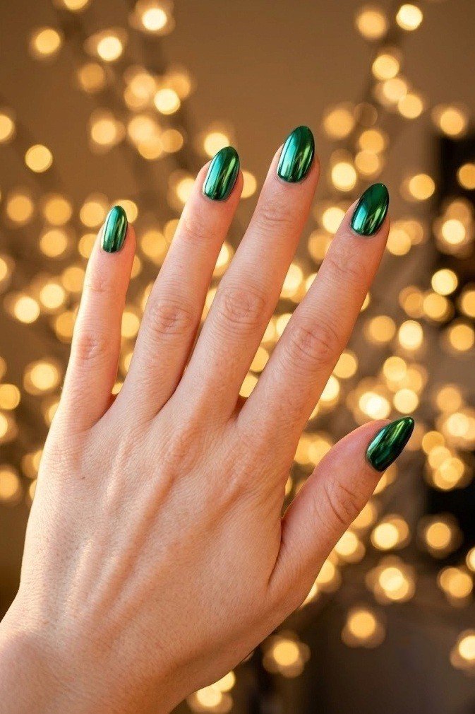 Emerald green mirror chrome short almond nails with a high-shine reflective finish.