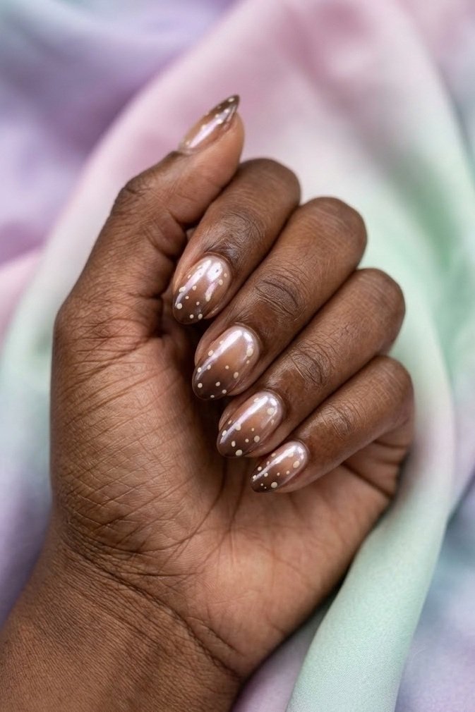 Glazed chocolate fawn nails with pearl chrome shimmer over cream spots on short almond nails