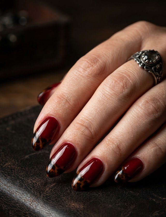 Gothic blood-red tortoiseshell French tips on short almond nails