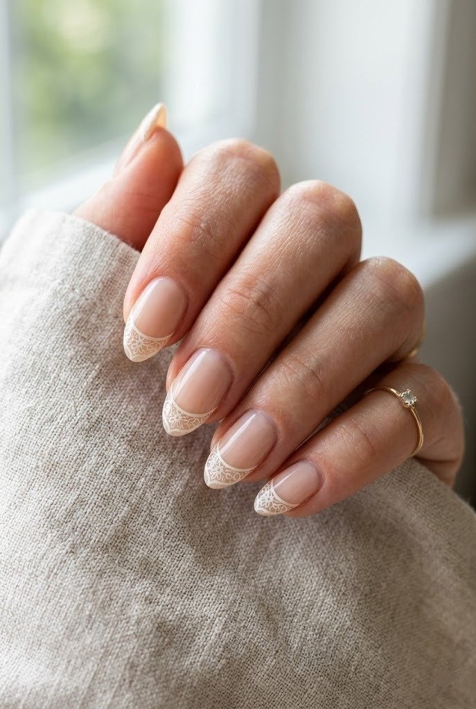 Short almond nails with delicate ivory filigree lace tips