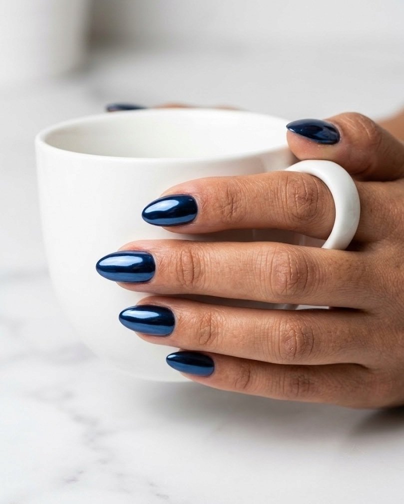 Navy mirror chrome short almond nails with a liquid-metal shine on white marble