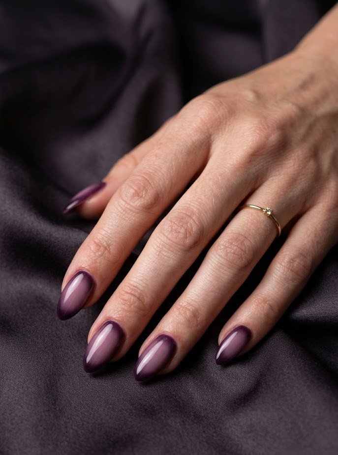 Plum aura nails with glowing mauve centers on almond shape