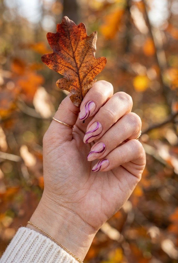 Plum chrome swirls over sheer base on almond nails