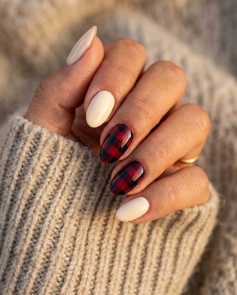 Short almond nails with two crimson and black buffalo check accent nails and warm cream nails