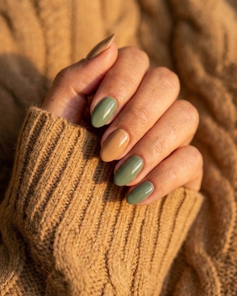 Short almond nails in sage green paired with camel tan on a medium skin tone hand