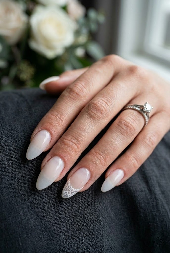 Sheer veil white nails with a single delicate lace tip on long almond