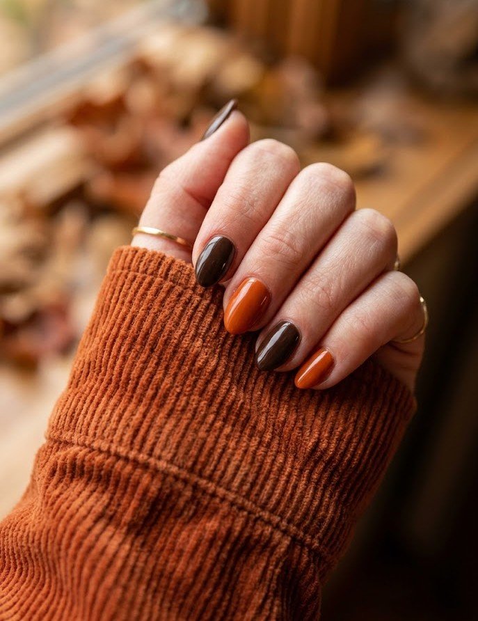 Short nails with burnt orange and espresso brown alternating skittle manicure