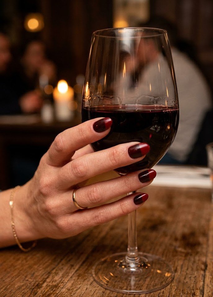 Short wine red nails with a gold chrome accent for holiday parties