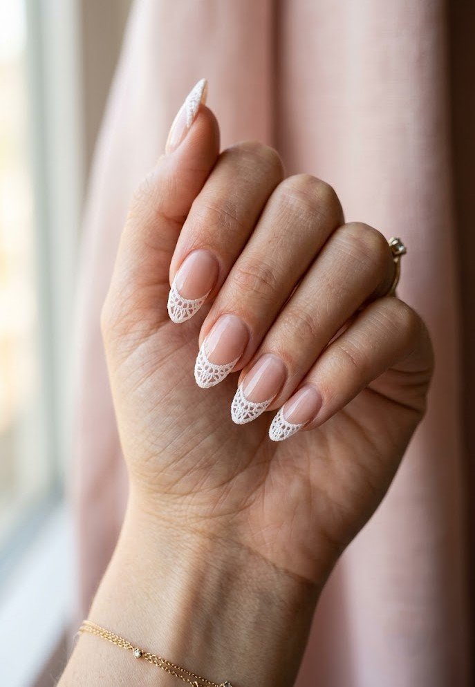 White doily-pattern French tip nails on almond shape