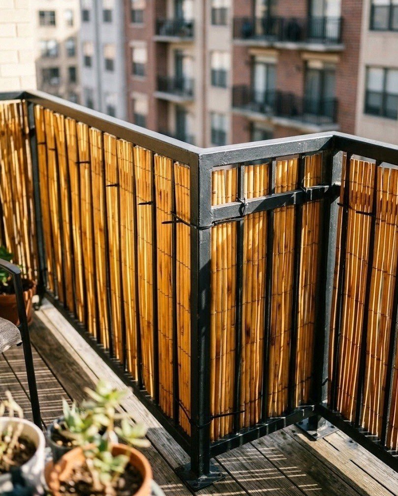 Honey-toned bamboo fencing roll zip-tied along a black balcony railing