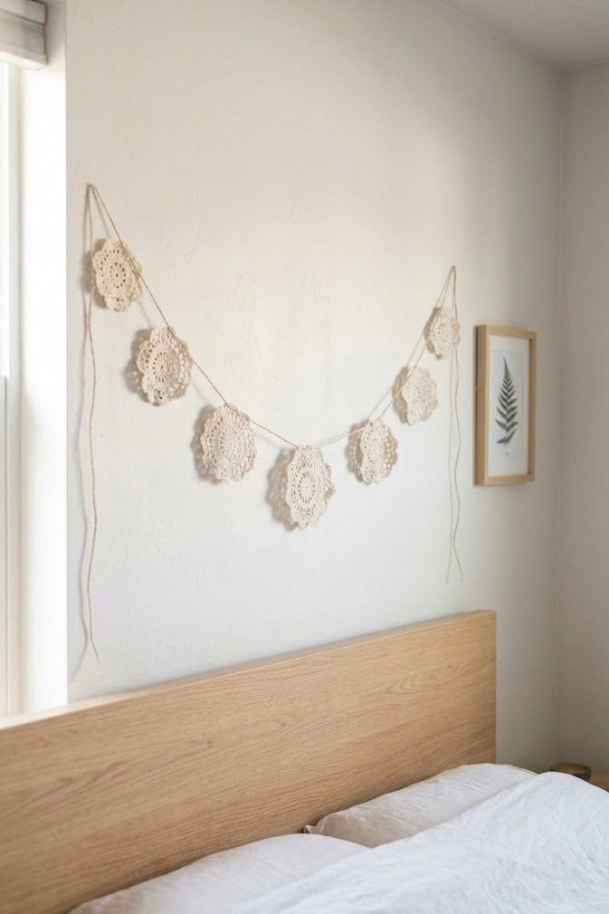 small cream doilies strung on twine as a garland above a headboard