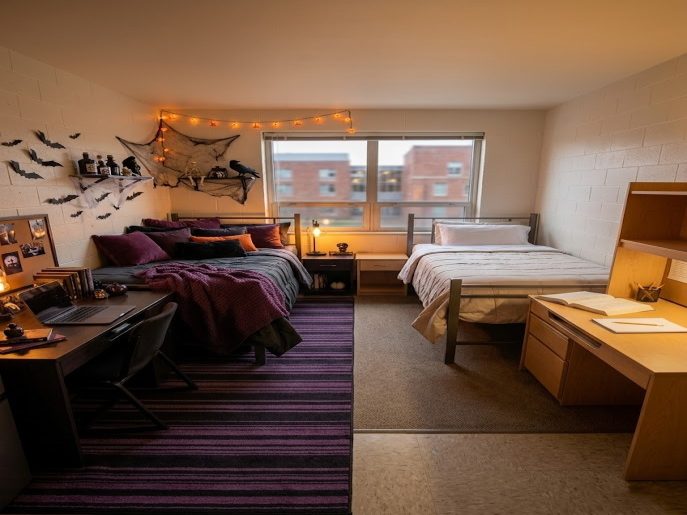 One side of a shared dorm styled moody plum, the other left plain