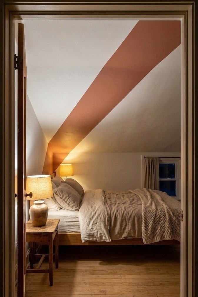 A single wide muted terracotta diagonal band cutting corner to corner across a white ceiling