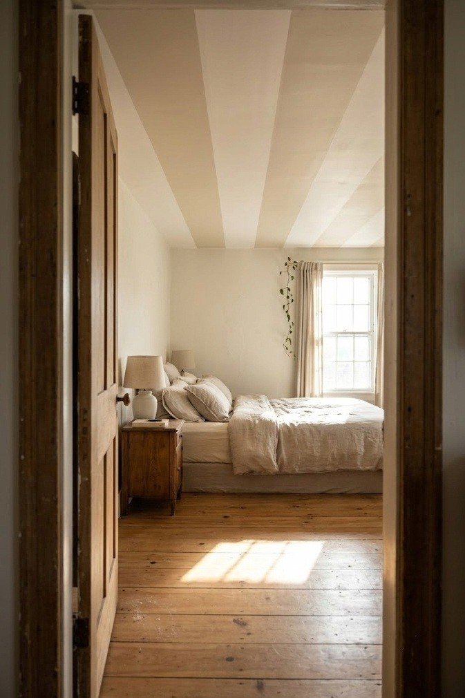 Wide two tone lengthwise ceiling bands running the long way over a low bed